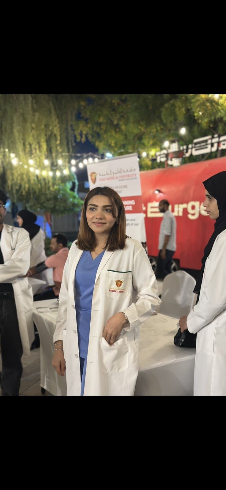 Afraa at a Non-Communicable Disease awareness event in her GMU white coat